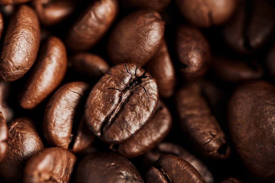The Roast Detail Wall Mural features a close-up of roasted coffee beans, highlighting their rich brown color, textured cracks, and glossy finish—ideal for custom printed or peel and stick wall murals.