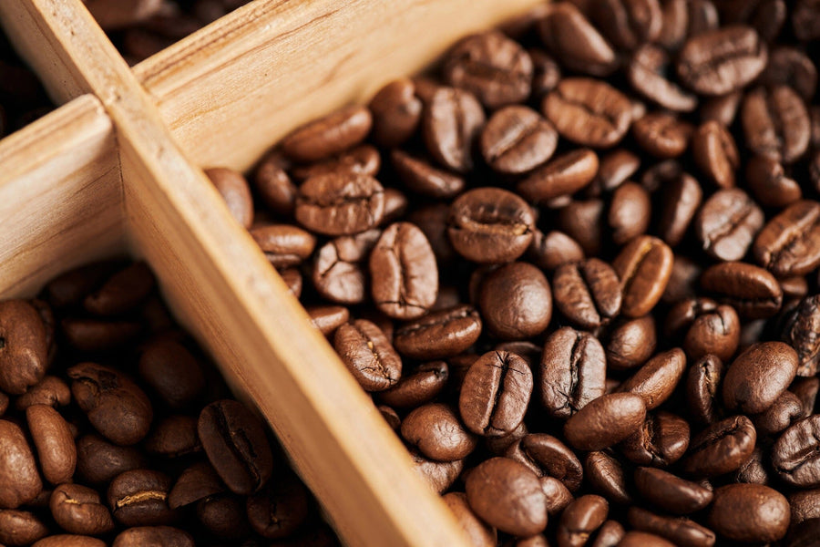 The Coffee 8 Wall Mural features a close-up of dark brown, glossy roasted coffee beans in a wood divider—perfect as custom printed or removable wall decor to create an inviting atmosphere for any coffee lover’s space.