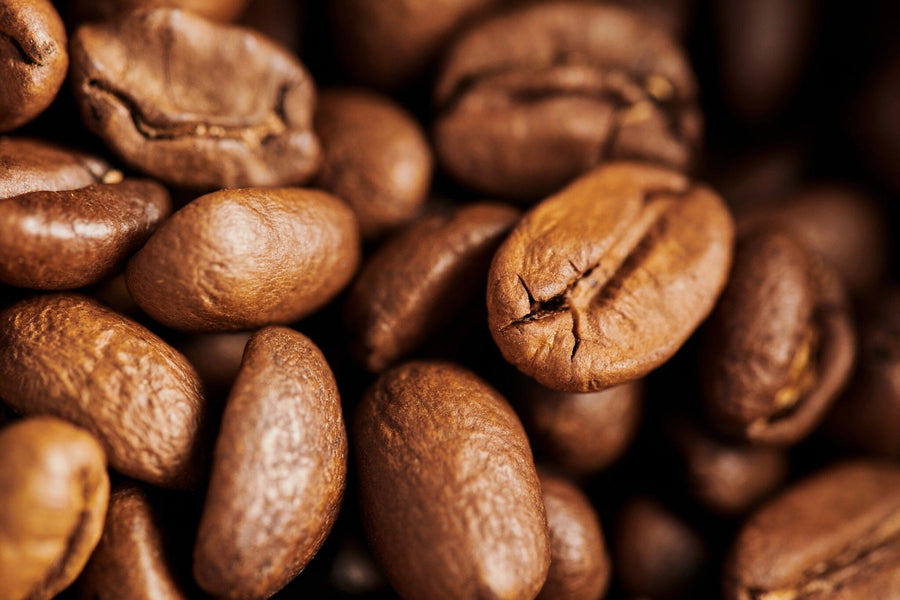 A close-up image of roasted coffee beans highlights their rich texture and color. The Coffee 9 Wall Mural is perfect for adding inspiration to your kitchen or café with custom printed or peel and stick wall décor.