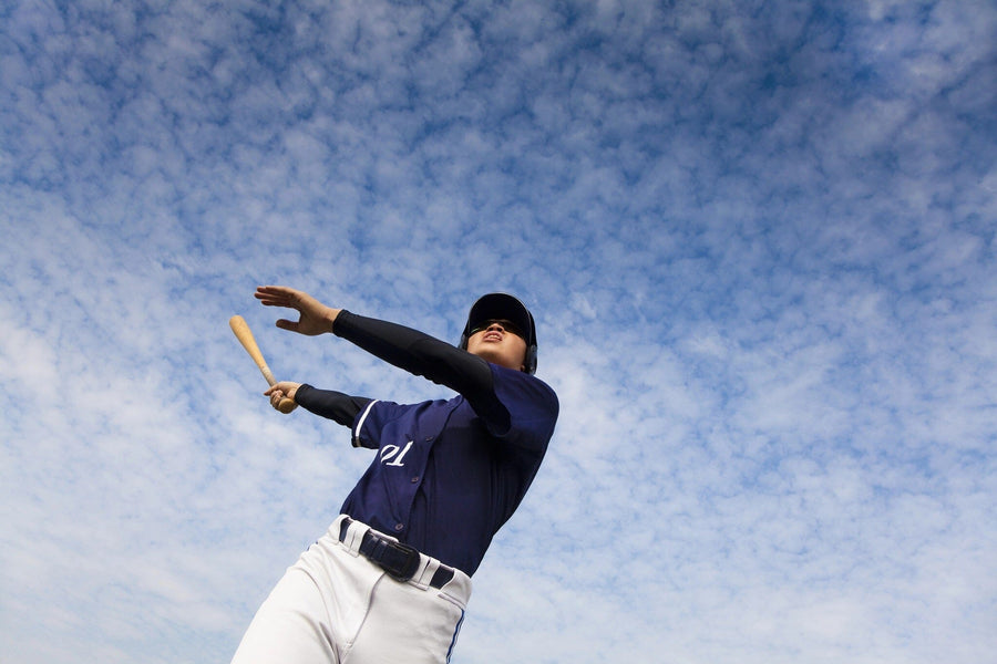 Bring dynamic energy to any space with the Baseball 10 Wall Mural, featuring a baseball player in a navy uniform and cap swinging a bat against a bright, cloud-filled sky. This commercial grade peel and stick mural is perfect for sports fans.