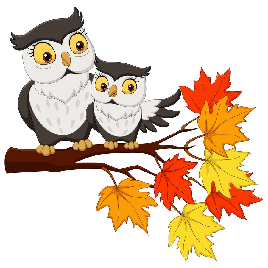 A nursery with gray walls and a white crib features the Mother and Baby Owl Wall Mural—a peel-and-stick design of two cartoon owls on a branch with autumn leaves. A dresser, plant, rug, framed photos, and toys complete the cozy space.