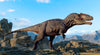 The Mountain Valley Dinosaur Wall Mural features a lifelike Tyrannosaurus rex with textured skin among rocky terrain, while a pterosaur soars in the blue sky—perfect for peel and stick decor.