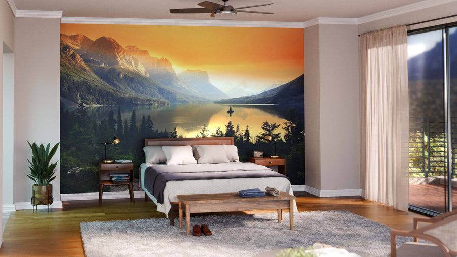 A modern open-plan living and dining room with wooden floors, mid-century furniture, rugs, and a large Mountains Over Saint Mary Lake Wall Mural at sunset creates a warm, inviting atmosphere.
