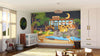 A nursery showcases the Night Zoo Wall Mural, displaying cartoon cheetahs at a nighttime zoo with a crescent moon, rocks, trees, and a pond. The room is furnished with a crib, toys, baskets, rocking horse, rug, and curtained windows.