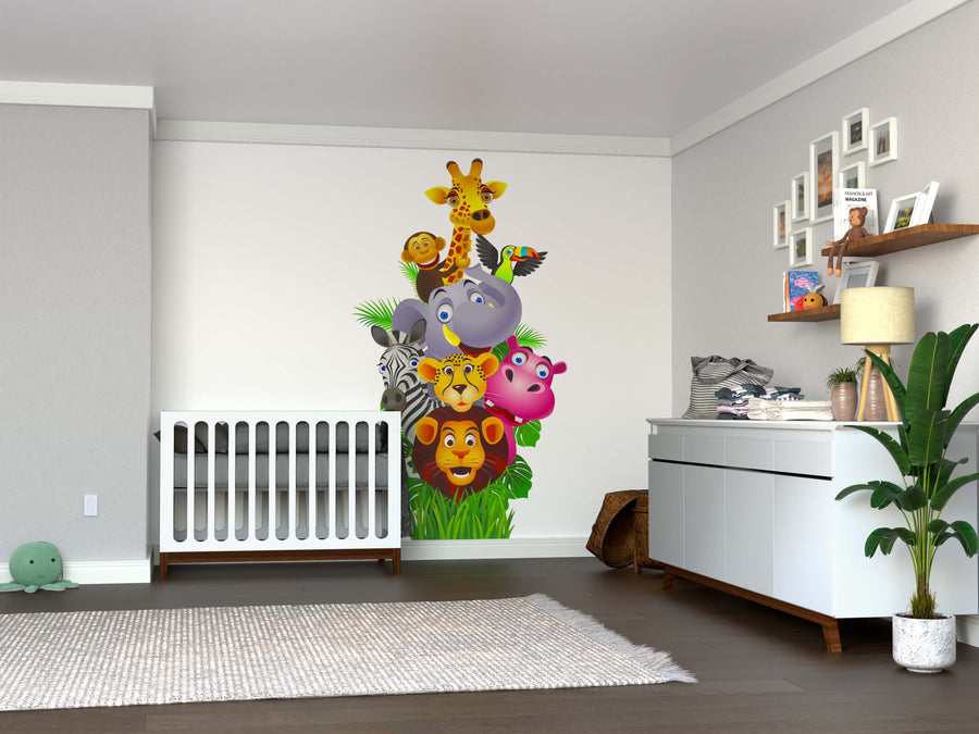 A nursery with gray walls and wood floors features a white crib, dresser with plant, shelves, and the Animals in the Jungle Wall Mural of stacked cartoon animals. Toys and decor are neatly arranged.