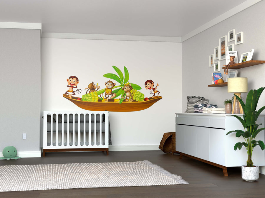 A nursery room with a white crib, dresser, green plant, and a Banana Boat Wall Mural featuring cartoon monkeys as removable wallpaper. Toys, books, photo frames line the shelves and a soft rug covers the wooden floor.