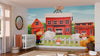 A nursery features the Barnyard Adventures Wall Mural with red barns, sheep, and chickens. A white crib, round organizer, wicker basket, and toys sit on a tan rug. Sunlight filters through sheer curtains beside a round mirror.