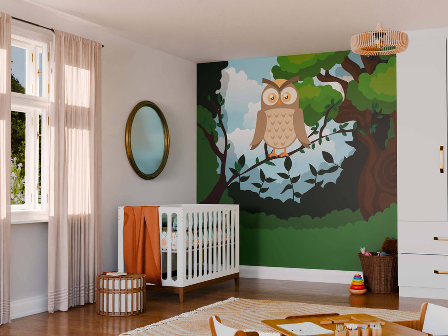 A nursery with a white crib, orange blanket, round mirror, and wicker stool. Light streams in from sheer curtains onto the Calm Owl Wall Mural—showcasing a cartoon owl on a leafy branch under a blue sky.
