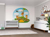 A nursery includes a crib, dresser, plant, and the Cartoon Monkeys Wall Mural showing monkeys on a log with bananas and trees for a playful jungle scene. Removable wallpaper adds charm alongside wooden floors and framed shelf photos.
