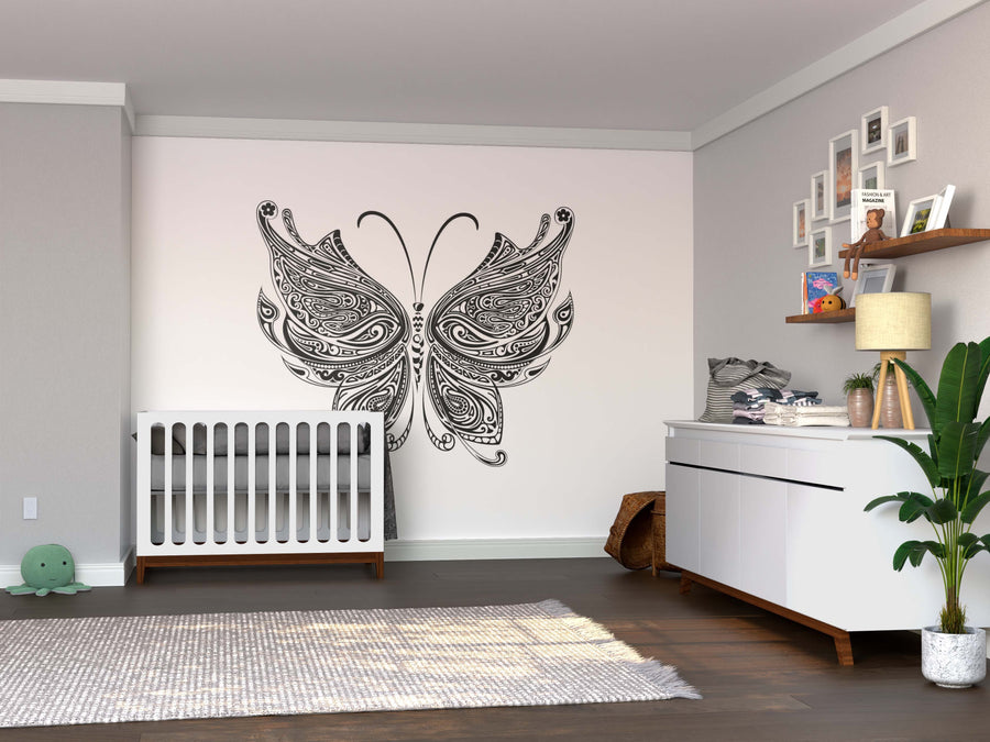 A nursery with a white crib, dresser with lamp and plants, and the bold Color My Butterfly Wall Mural. Framed photos hang above the dresser, toys on a shelf add charm, and a gray rug covers the wooden floor.
