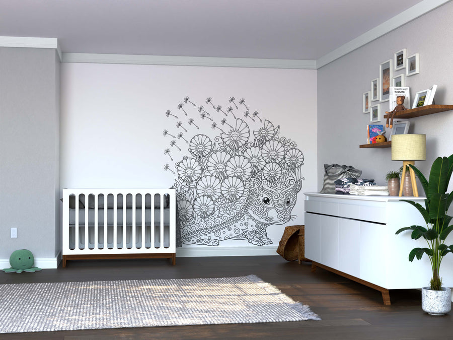 A modern nursery with gray walls features a white crib, a white dresser with a plant, shelves with toys and photos, the Color My Dandy Lions Wall Mural, plus a woven basket and plush turtle on the gray rug.