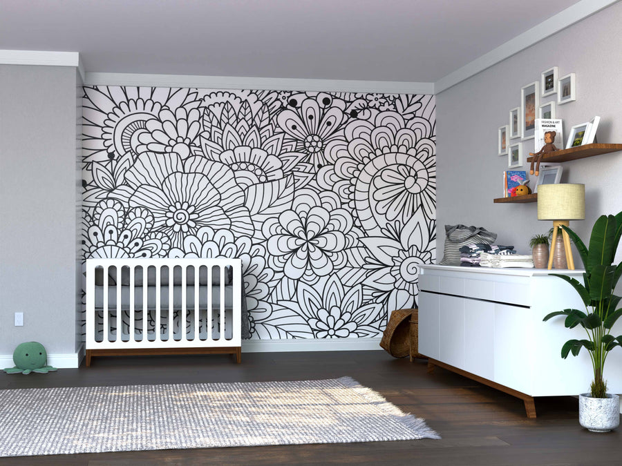 A modern nursery features a white crib, dresser, and open shelves against a gray wall. The accent wall displays the Color My Garden Wall Mural. A green plant, wicker basket, and gray rug add warmth atop dark wood floors.