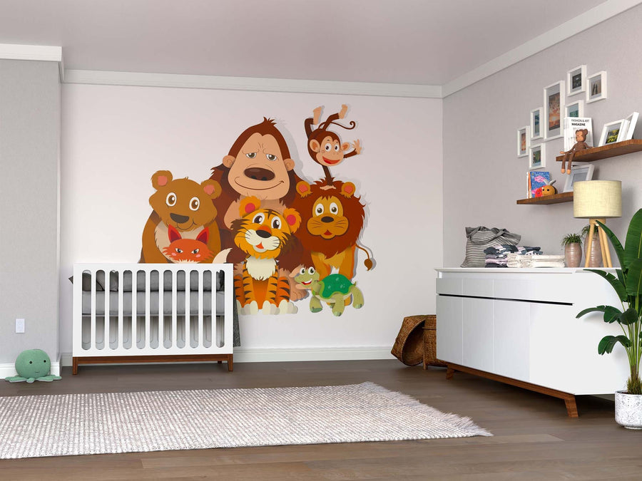 A nursery with a white crib, dresser, plants, and shelves features a large, colorful Cute Jungle Animals Wall Mural—smiling cartoon gorilla, monkey, bear, lion, tiger, turtle, and cat standing close together on the wall.