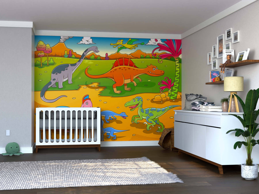 A nursery with a white crib, dresser topped with baby items, wooden floors, and shelves with pictures and toys displays the Dino Day Out Wall Mural—colorful cartoon dinosaurs and plants—plus a green plant in the corner.