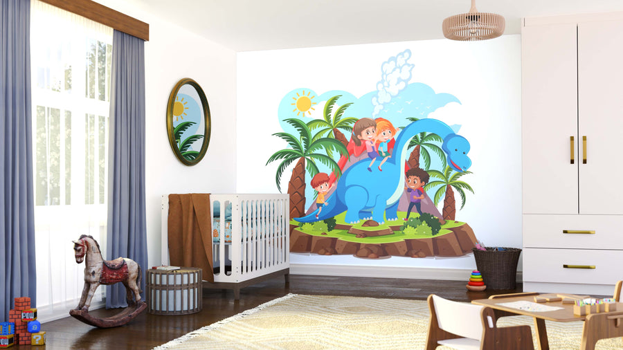 A bright, tidy kids’ room features the Dino Fun Wall Mural showing four children riding a blue dinosaur among palm trees. A crib, wooden rocking horse, toys, baskets, and a cozy rug fill the space as sunlight streams through blue curtains.