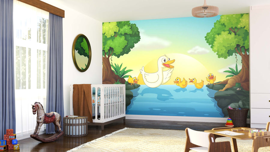 A bright nursery featuring the Duck Family Wall Mural of a mother duck and four ducklings by a pond, with green trees and sunrise. The room includes a crib, toy rocking horse, wicker basket, blue curtains, and scattered toys.