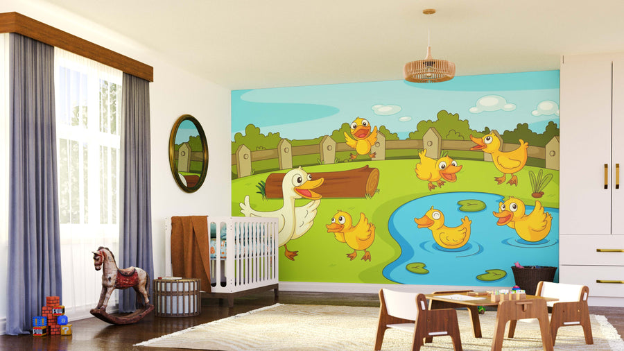 A nursery with a crib, rocking horse, and chairs features the Ducklings at Play Wall Mural—large, colorful, and peel-and-stick—showing cartoon ducks by a pond, fence, green grass, trees, and sky. Sunlight streams through a window with blue curtains.
