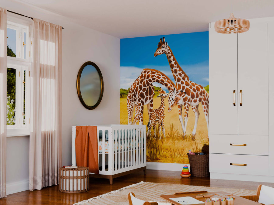 A nursery features a white crib, soft beige curtains, and a round mirror. The Giraffes Wall Mural decorates one wall. Toys and baskets are on the floor, with a tall white wardrobe standing to the right.