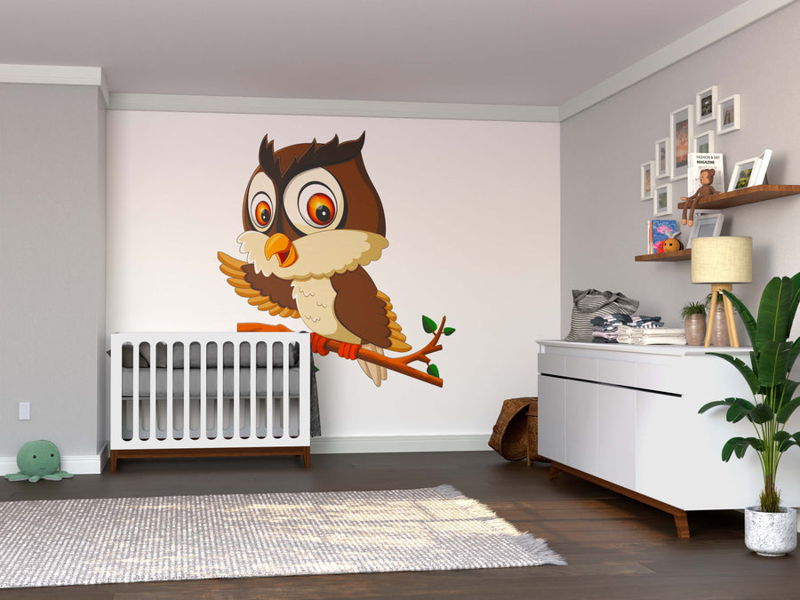 A modern nursery with a white crib, dresser, plant, and photos on shelves is brightened by the Happy Owl on Branch Wall Mural above the crib, adding playful charm to the gray walls, wood floors, and cozy decor.