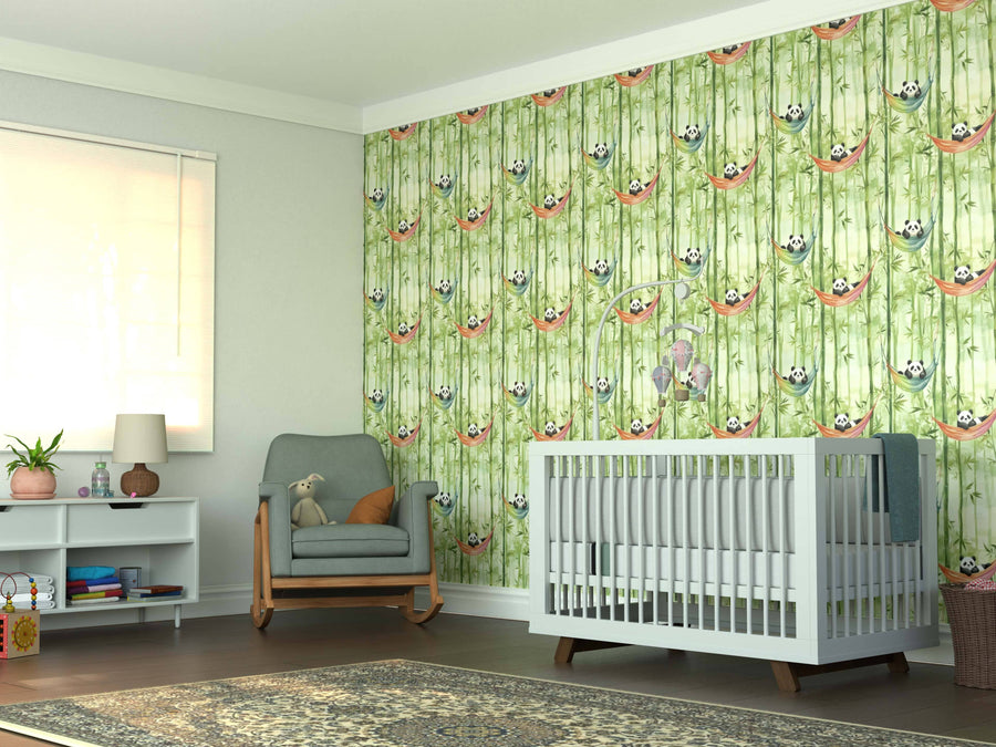 Bright nursery featuring the Lazy Panda Wall Mural, a white crib, gray cushioned rocking chair with a stuffed toy, white shelf with books and lamp, large window with blinds, and a patterned rug on brown flooring.
