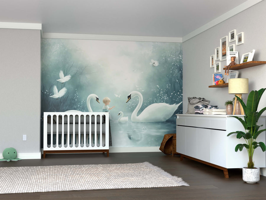 A nursery room with soft, neutral decor features the Little Swan Keeper Wall Mural—a large peel and stick scene of a child with two swans—above a crib and dresser, accented by plants, toys, and framed photos on shelves and walls.