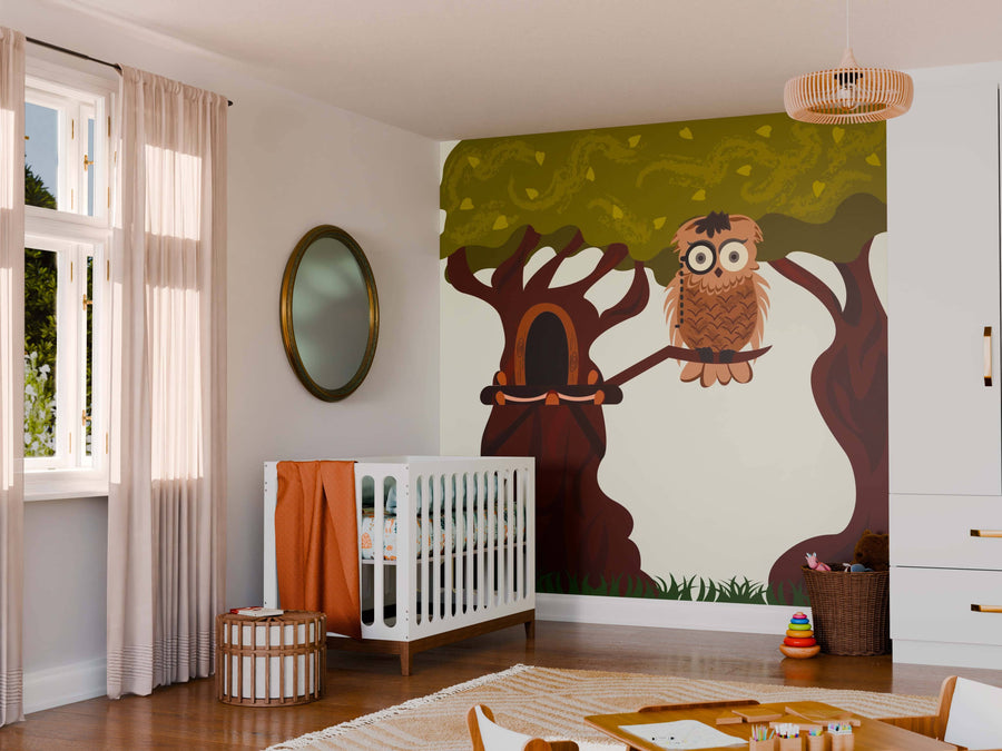 A cozy nursery features a white crib, round mirror, and the Monocle Owl Wall Mural with two leafy trees and an illustrated owl on a branch beside a tree with a door. Soft light highlights toys and a rug on the wooden floor.