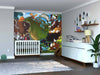 A nursery with a white crib and dresser features the vibrant Nature’s Creatures Wall Mural of forest animals behind the crib. Shelves with decor, framed photos, a potted plant, and hardwood floors complete the charming space.