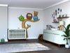 A modern nursery with a white crib, Owl Group Wall Mural, dresser and changing mat, shelves with photos and toys, wicker basket, potted plant, and wooden floor. Soft light creates a cozy, organized space for a baby.