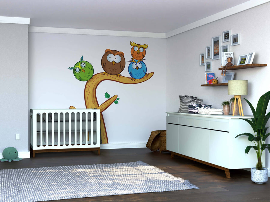 A modern nursery with a white crib, Owl Group Wall Mural, dresser and changing mat, shelves with photos and toys, wicker basket, potted plant, and wooden floor. Soft light creates a cozy, organized space for a baby.