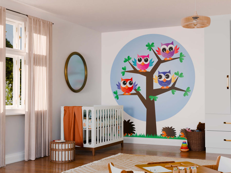 A nursery features a white crib, round mirror, and a large Owls and Hedgehogs Wall Mural. Sheer curtains let in light, while toys and a basket on the floor create a playful, cozy atmosphere.