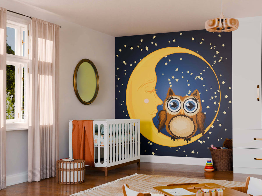 A nursery with a crib, wicker basket, toys, and a round mirror. The feature wall displays the "Starry Night with Owl Wall Mural," showing a yellow crescent moon, stars, and an owl. Sunlight from the window brightens the playful space.