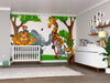A nursery with a crib, dresser, and shelves features the Wildlife Group Wall Mural—colorful, peel-and-stick cartoon jungle animals under green trees—creating a cheerful atmosphere that’s easy to update with removable wallpaper.