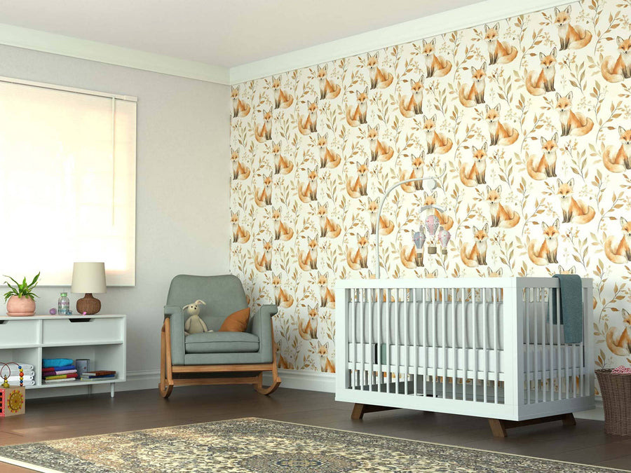 A cozy nursery features a white crib, green cushioned rocking chair with a plush toy, white shelf with books and lamp, large window, wooden floor with patterned rug, and an accent wall adorned with the Woodland Foxes Wall Mural.