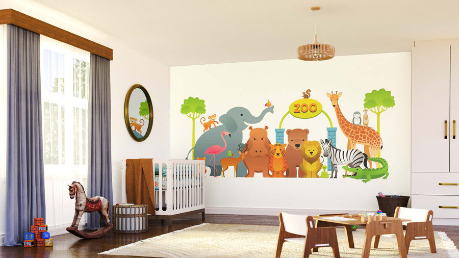 A bright, airy nursery features the Zoo Crew Wall Mural with cartoon elephant, giraffe, lion, bear, monkey, zebra, and crocodile. The room includes a crib, rocking horse, toys, soft rug, and a large window letting in natural light.