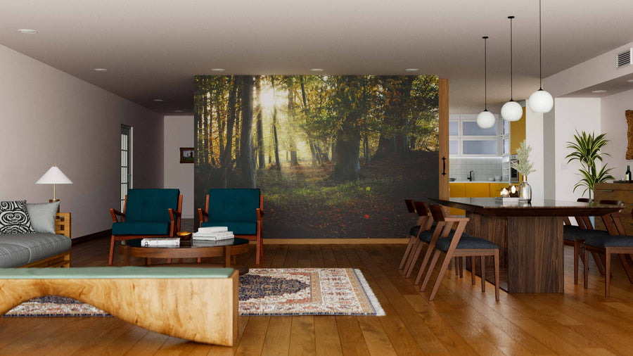 A modern living-dining area features wood flooring, teal armchairs, a wooden table, pendant lights, and the Old Forest in Autumn Wall Mural. A rug, sofa, and decor complete the cozy atmosphere with a touch of natural charm.