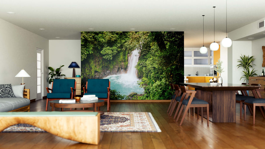 A modern living and dining room with wood floors and mid-century furniture features the “Rainforest Jungle of Costa Rica Wall Mural,” bringing a lush, nature-inspired vibe to the bright, open-concept space.