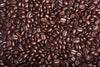 The Rich Coffee Beans Wall Mural by Photo features a detailed close-up of glossy, dark brown beans in varying sizes and shapes, highlighting their natural texture and color against a backdrop similar to peel-and-stick wall murals.