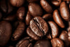 The Roast Detail Wall Mural features a close-up of roasted coffee beans, highlighting their rich brown color, textured cracks, and glossy finish—ideal for custom printed or peel and stick wall murals.