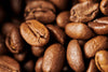 A close-up image of roasted coffee beans highlights their rich texture and color. The Coffee 9 Wall Mural is perfect for adding inspiration to your kitchen or café with custom printed or peel and stick wall décor.