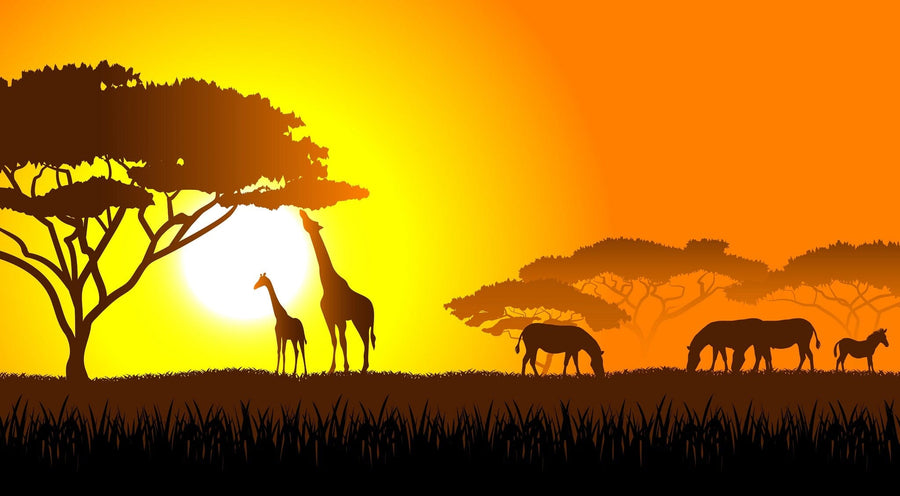 A nursery room features a white crib, gray armchair, shelves, and the Savanna Sunset Wall Mural—a peel and stick mural showing giraffe and elephant silhouettes under a yellow-orange sunset. A rug and baby mobile complete the cozy space.