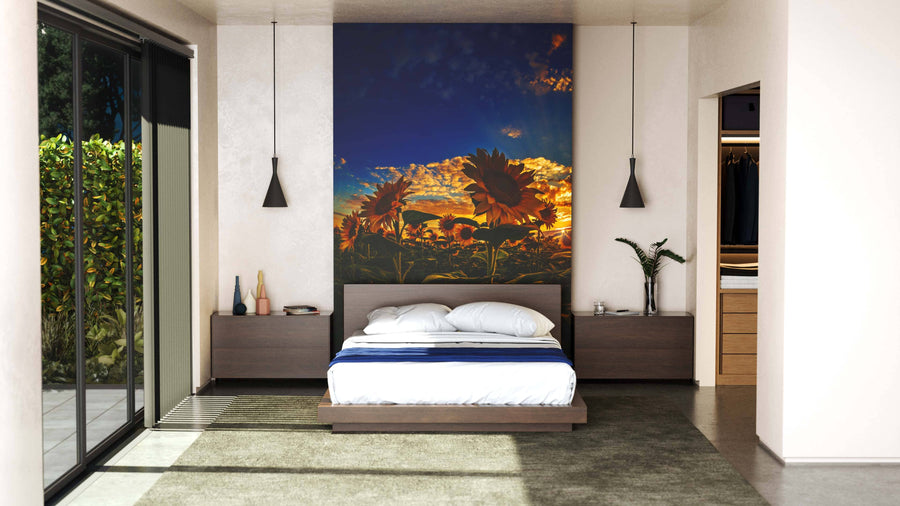A modern bedroom with a low platform bed, two pendant lights, and the Sea of Golden Sunflowers Wall Mural behind the headboard. Floor-to-ceiling windows reveal greenery and minimal earthy decor complements a visible walk-in closet.