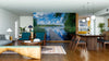 A modern open-plan living and dining room with wooden floors, green chairs, and the Sky on Water Wall Mural. Pendant lights hang above a dark table as sunlight brightens the stylish interior with this cozy peel and stick wall mural.