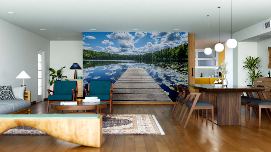 A modern open-concept living and dining area is enhanced by the Still Lake Wall Mural, a large peel and stick design featuring a dock on a calm lake. Wood floors, mid-century furniture, and pendant lights bring nature indoors with style.