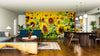 A modern living-dining room with wood floors, mid-century furniture, and a large Summer Blossoms Wall Mural featuring sunflowers. Plants, pendant lights, and teal accents complete the warm, inviting atmosphere.