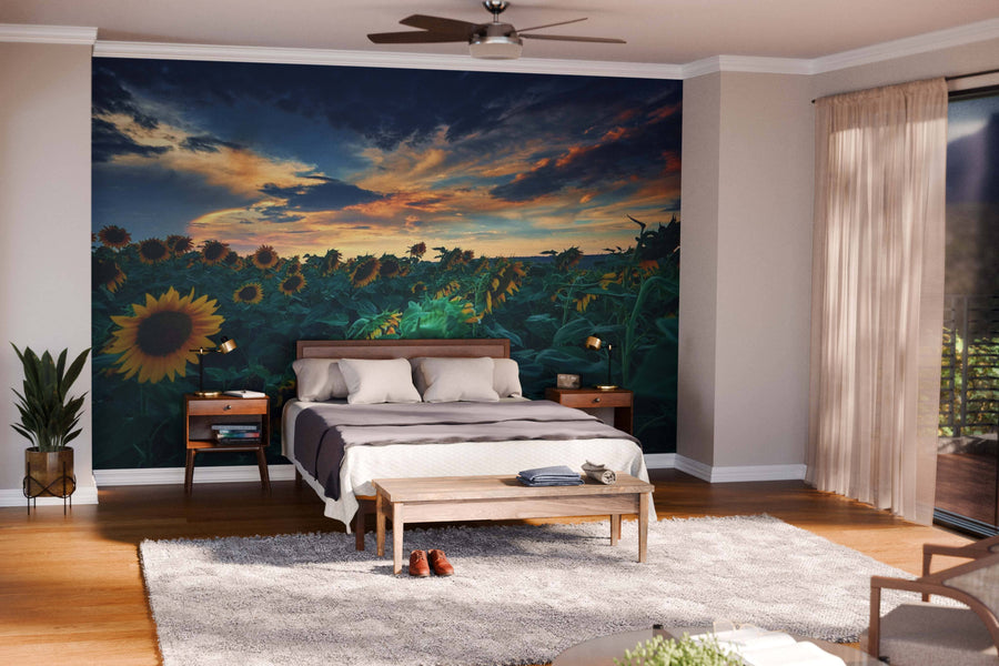 A modern bedroom showcases "A Beautiful Sunflower Field Wall Mural" behind the bed, complemented by light walls, wooden furniture, a soft rug, and sheer curtains on floor-to-ceiling windows for an airy, inviting feel.