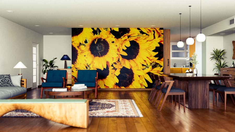 A modern open-concept living and dining room features wood floors, mid-century furniture, and the Sunflower Symphony Wall Mural. Plants, rugs, and pendant lights add to the bold yet cozy atmosphere.
