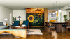 Modern open-plan living and dining space with wood flooring, dark blue and wood furniture, pendant lights over the dining table, and a striking Sunflowers Wall Mural under a sunset sky; the kitchen can be seen in the background.