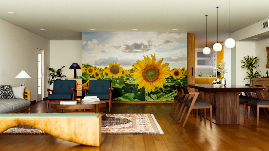 A modern, open-concept living and dining room with wood floors and contemporary furniture is brightened by the Sunflowers Under Clouds Wall Mural, adding vibrant yellow and green accents and creating a stylish, cozy atmosphere.