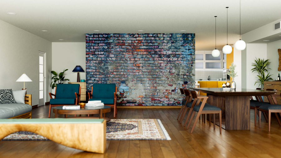 A modern living and dining area features wooden floors, teal armchairs, a gray sofa, and a multicolored rug. The Old Stuccoed Brick Wall Wall Mural adds character to the brick accent wall. Pendant lights brighten the wooden dining set.