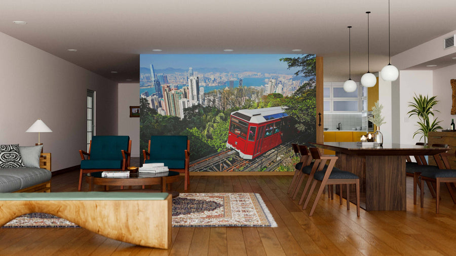 A modern living-dining room features the Tourist Tram at the Peak Wall Mural, showcasing a red funicular against lush hills and a city skyline; mid-century furniture, wood floors, rugs, and pendant lights blend urban and natural themes.